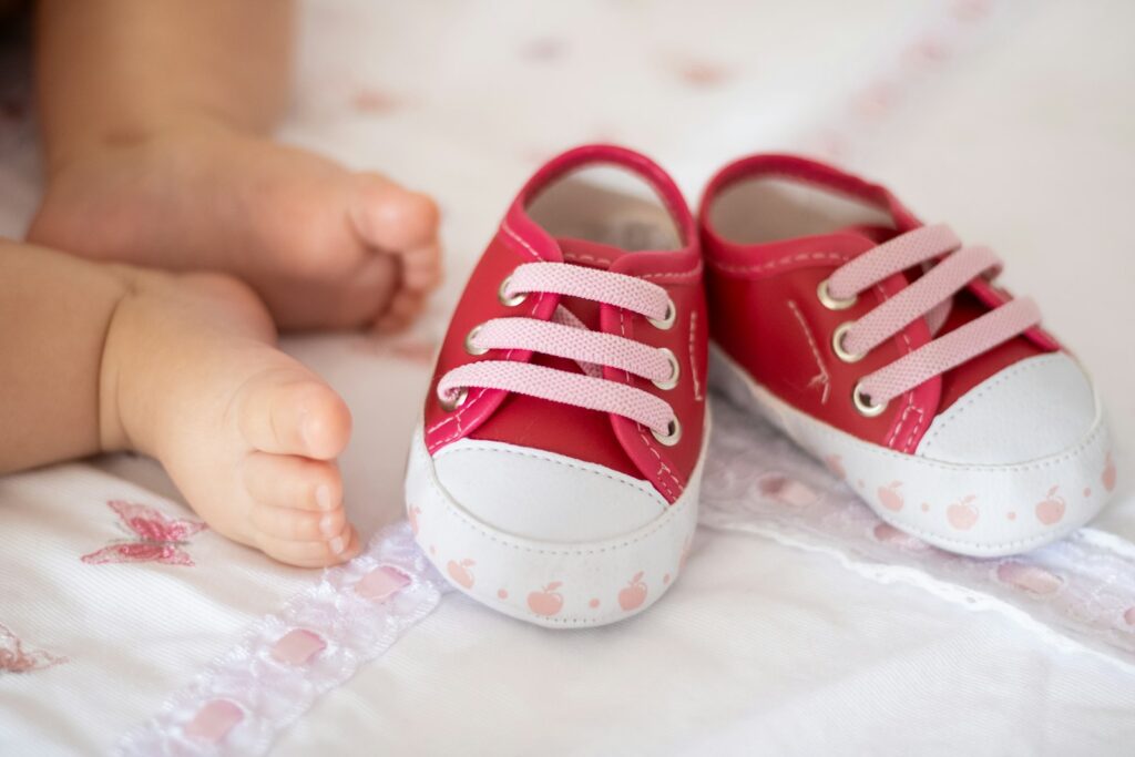 A parent holding a pair of baby shoes