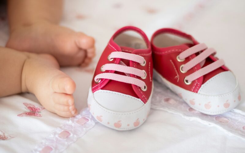 A parent holding a pair of baby shoes